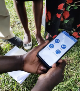 TaroWorks App open on a mobile phone in the field, Kiima Foods user